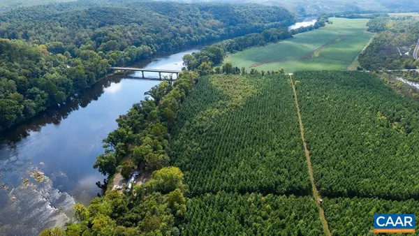 an aerial view of green landscape with trees and houses