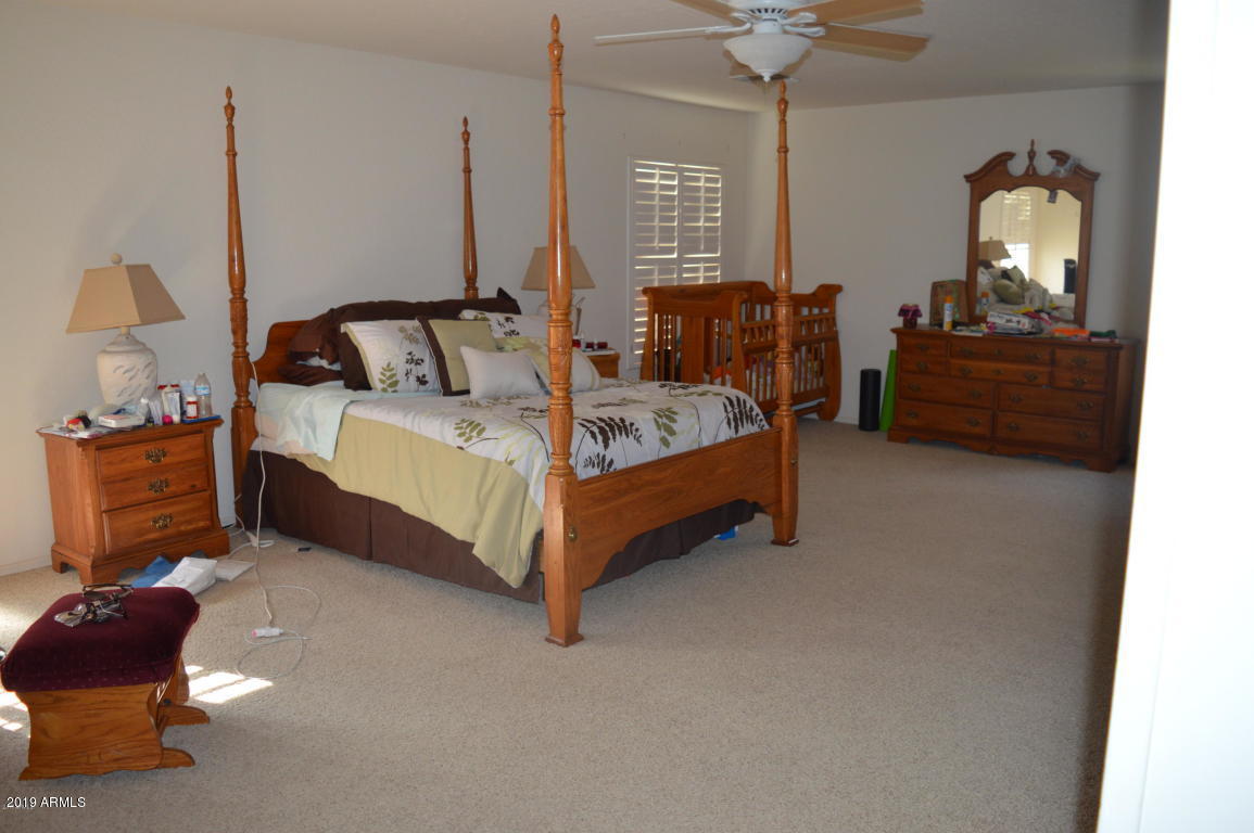 4351 East Pinto Valley Road San Tan Valley, AZ 85143 - Photo 14 of 27 a bed room with a bed and a chandelier
