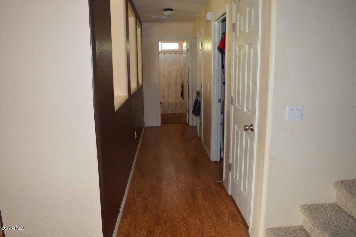4351 East Pinto Valley Road San Tan Valley, AZ 85143 - Photo 8 of 27 a view of a hallway with wooden floor and a bathroom