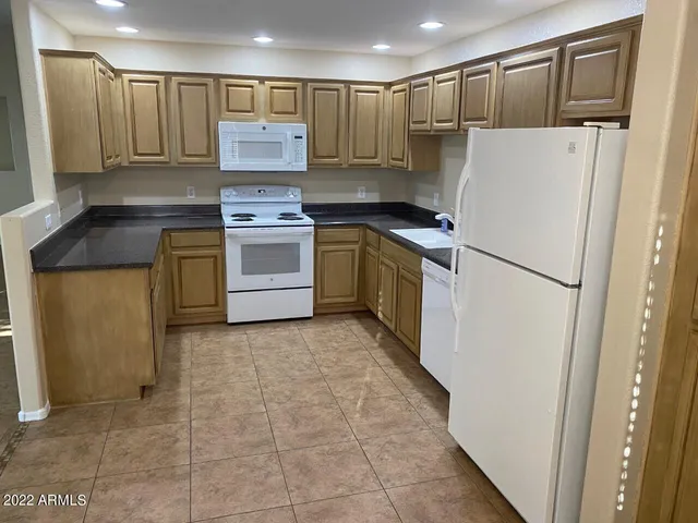 a kitchen with a refrigerator sink and cabinets