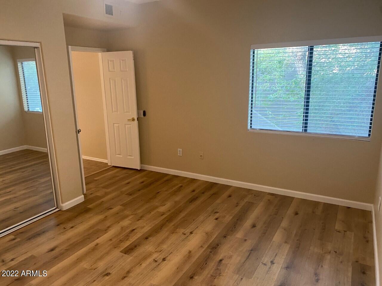 15225 North 100th Street, Unit 2188 Scottsdale, AZ 85260 - Photo 14 of 24 a view of an empty room with wooden floor and a window