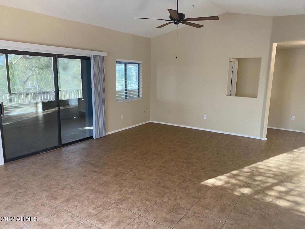 15225 North 100th Street, Unit 2188 Scottsdale, AZ 85260 - Photo 4 of 24 an empty room with chandelier fan and windows