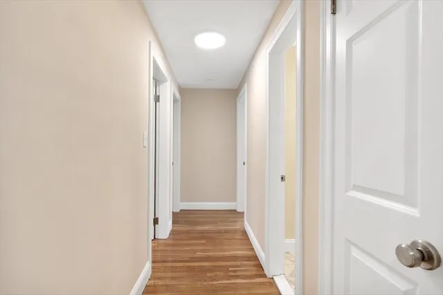 a view of a hallway with wooden floor and entryway