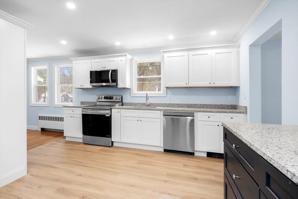 36 Grove Street Hanover, MA 02339 - Photo 4 of 25 a kitchen with granite countertop a stove top oven and cabinets