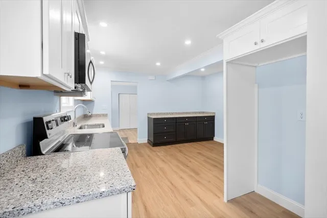 a kitchen with stainless steel appliances granite countertop a sink stove and refrigerator