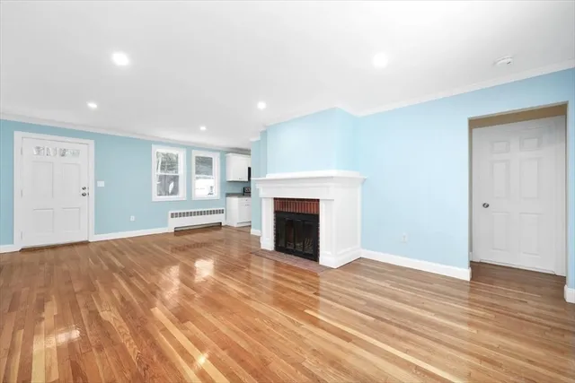 a view of empty room with wooden floor and fireplace