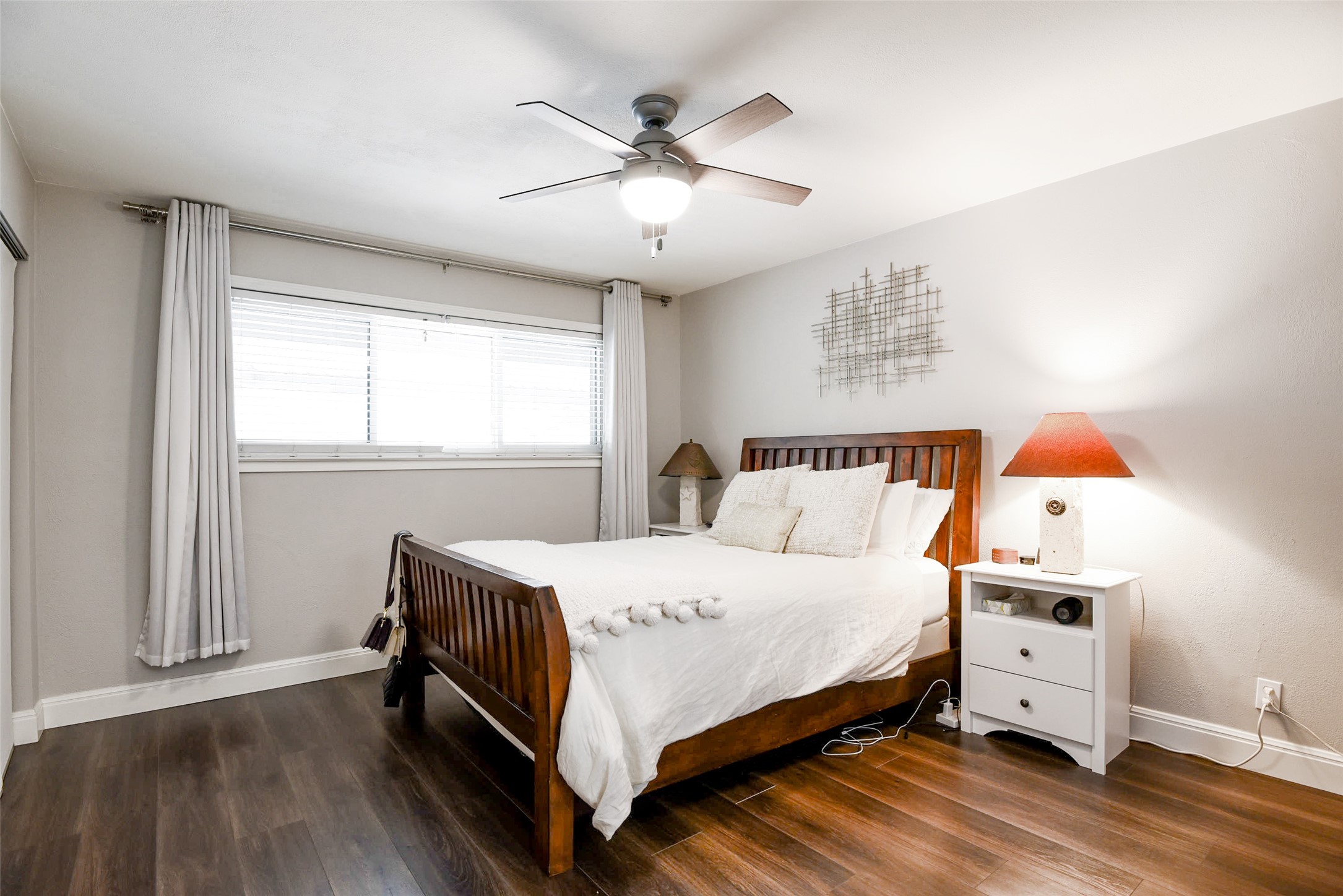 1210 Windsor Road, Unit 119 Austin, TX 78703 - Photo 8 of 15 Rich wood-inspired floors and a wide window create a comfortable, inviting atmosphere.