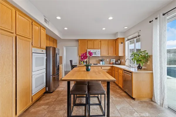 a kitchen with a table chairs refrigerator and microwave