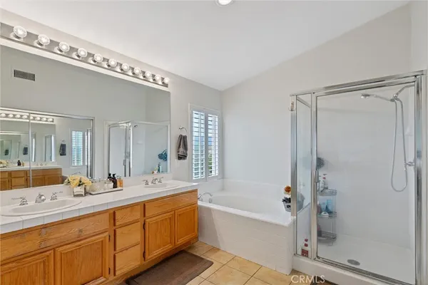 a spacious bathroom with a double vanity sink mirror and bathtub