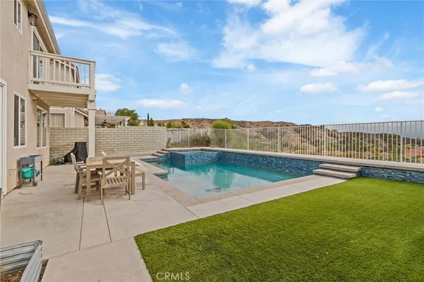 a view of a swimming pool with an outdoor seating and a yard