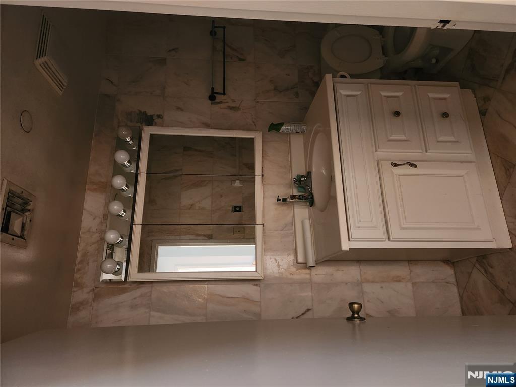 840 River Road, Unit B2 Edgewater, NJ 07020 - Photo 8 of 13 a bathroom with a sink a vanity and a mirror