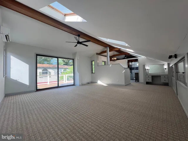 a view of an empty room with wooden floor and windows