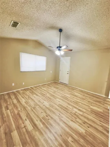 a view of a room with wooden floor and chandelier