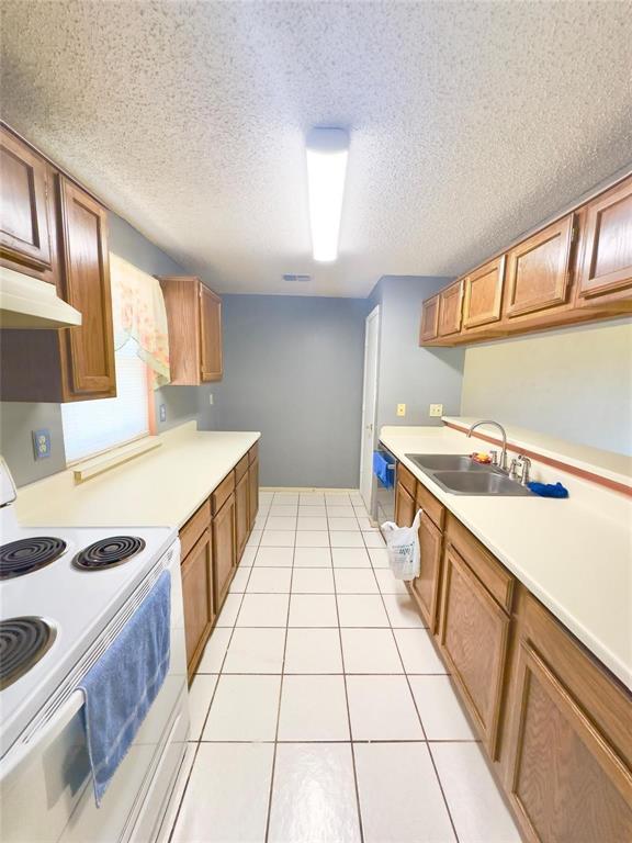 7401 Canoga Circle Fort Worth, TX 76137 - Photo 6 of 17 a kitchen with a sink a stove cabinets and a window