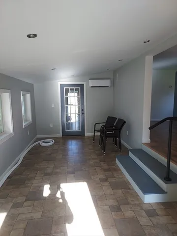 a view of a livingroom with lounge chair and a window