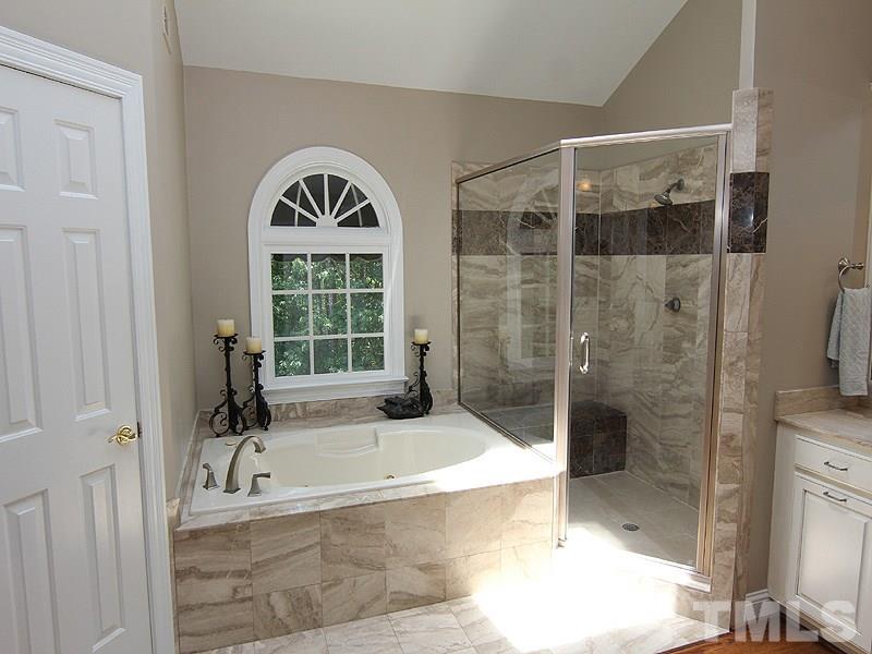 233 Markham Plantation Apex, NC 27523 - Photo 11 of 25 a bathroom with a bathtub and a shower