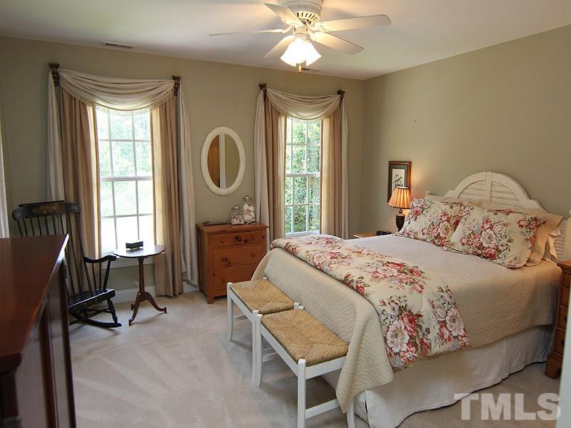 233 Markham Plantation Apex, NC 27523 - Photo 14 of 25 a bedroom with a bed and a chandelier