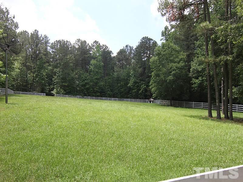 233 Markham Plantation Apex, NC 27523 - Photo 23 of 25 a view of a field with a trees in the background