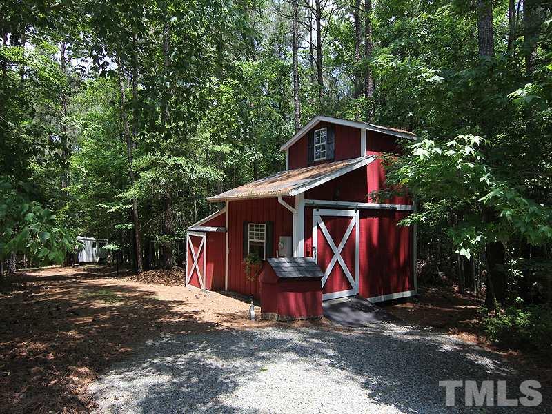 233 Markham Plantation Apex, NC 27523 - Photo 24 of 25 a view of a barn with wooden fence and a large tree