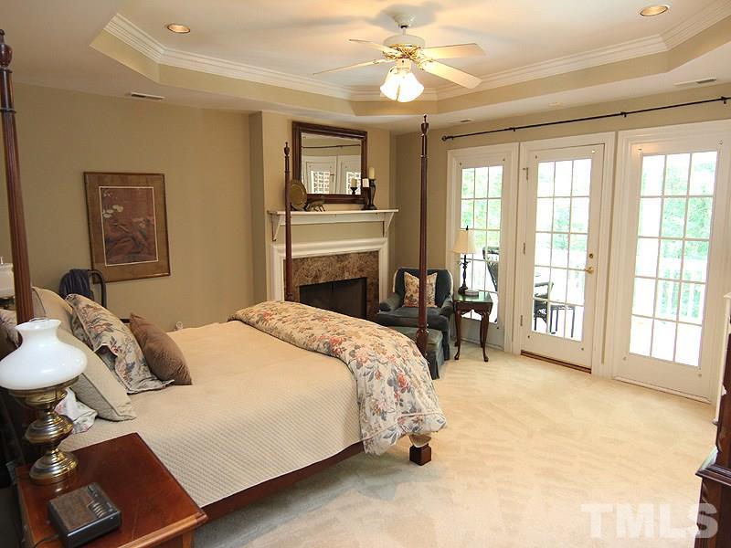 233 Markham Plantation Apex, NC 27523 - Photo 10 of 25 a bedroom with a bed and a chandelier