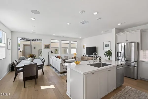 a kitchen with sink refrigerator and couches