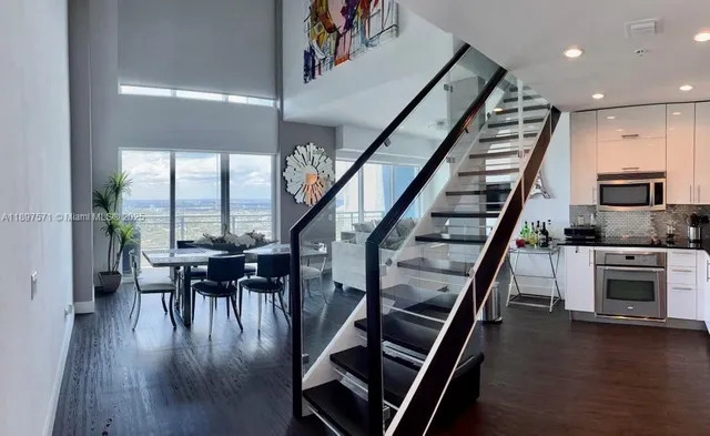 an open kitchen with furniture and wooden floor