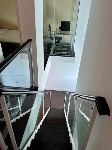 a view of a kitchen with fridge and wooden floor