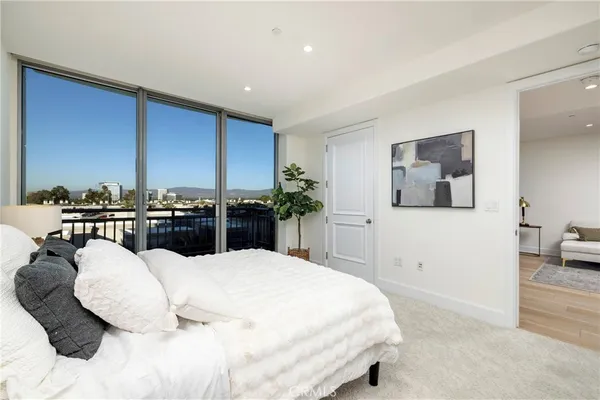 a bedroom with a large bed and a potted plant