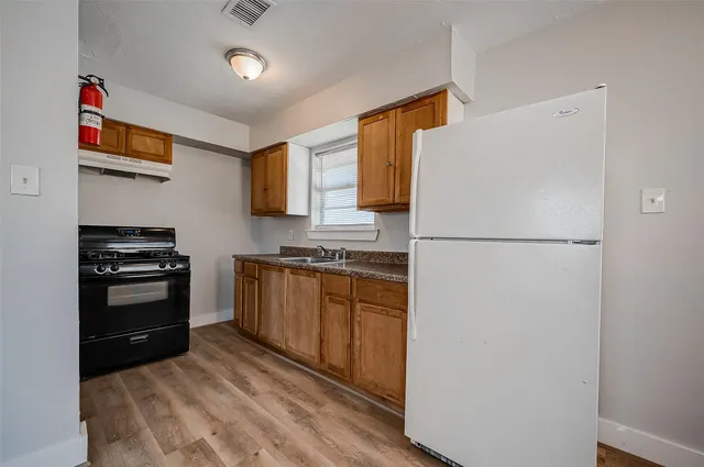 a kitchen with a refrigerator and a stove top oven