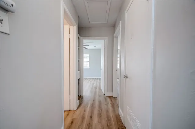 a view of a hallway with wooden floor