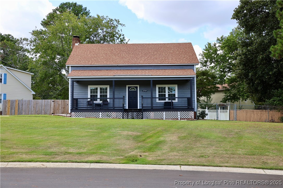 a view of a house with a yard potted plants and a large tree