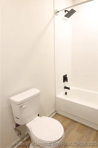 a white toilet sitting next to a bath tub and shower
