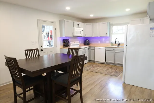 a kitchen with a dining table chairs and refrigerator
