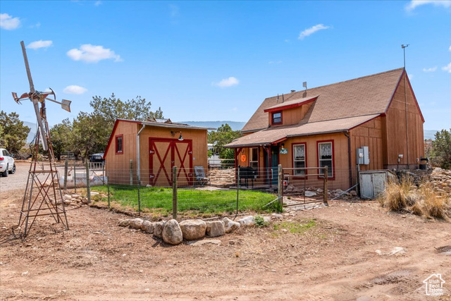 11450 Pigeon Hollow Road Spring City, UT 84662 - Photo 23 of 47 Rear view of house featuring an outdoor structure, an exterior structure, and a shingled roof