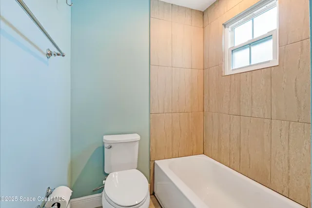 a white toilet sitting next to a bathroom sink and tub