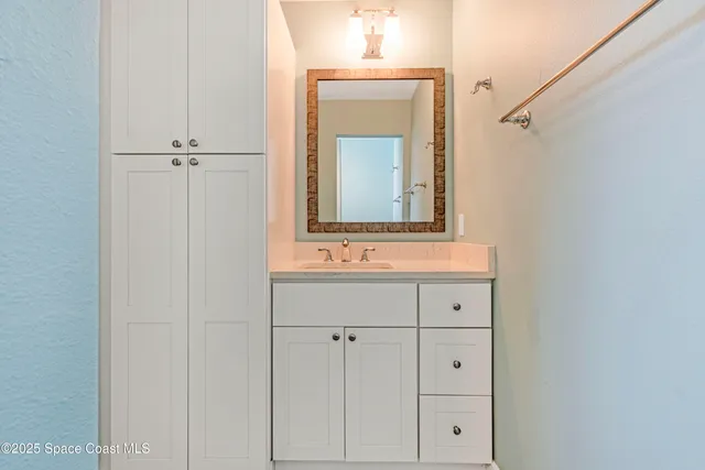 a bathroom with a sink vanity and mirror
