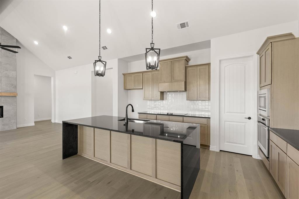 317 Slimp Bluff Azle, TX 76020 - Photo 12 of 25 a kitchen with kitchen island a sink stainless steel appliances and cabinets