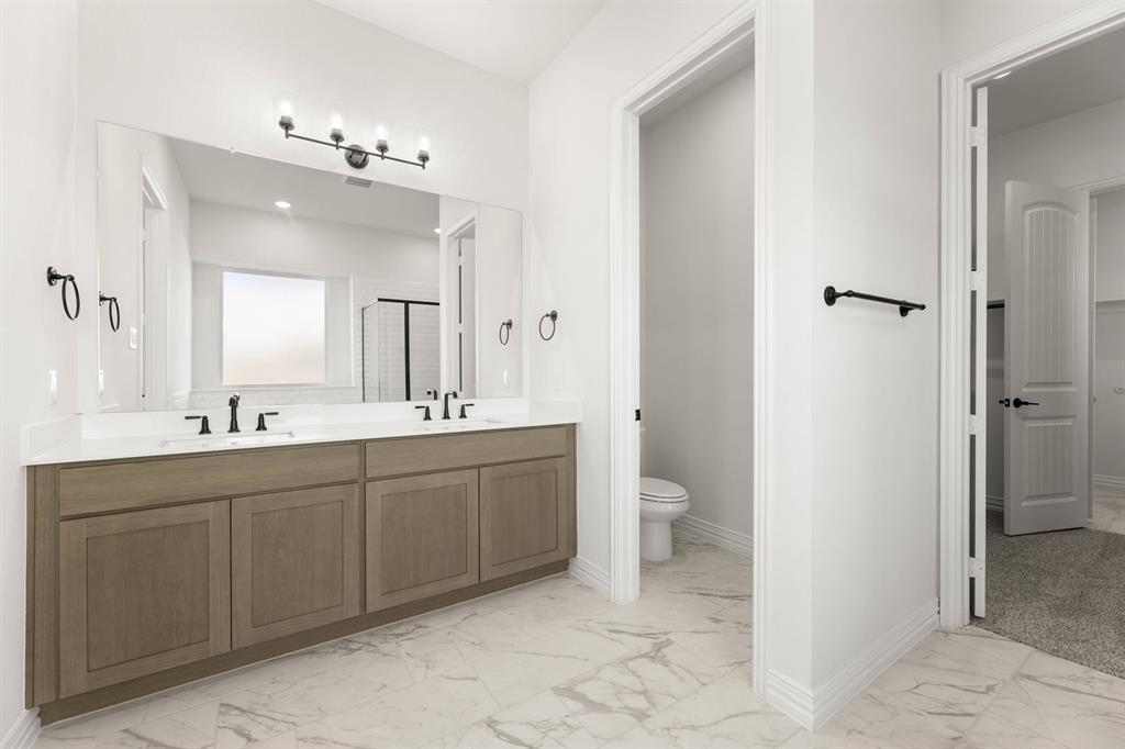 317 Slimp Bluff Azle, TX 76020 - Photo 18 of 25 a spacious bathroom with a double vanity sink a toilet and a large mirror