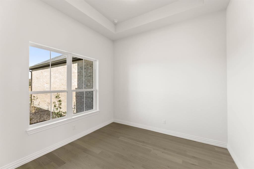 317 Slimp Bluff Azle, TX 76020 - Photo 3 of 25 an empty room with wooden floor and windows