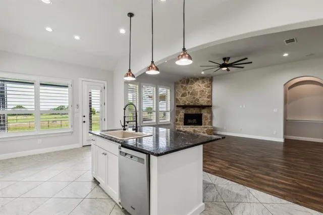 a kitchen with stainless steel appliances granite countertop a sink a stove and a granite counter tops