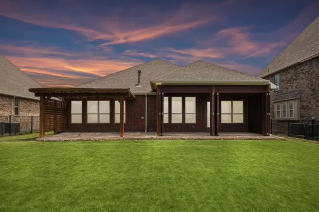 an empty room with wooden floor and kitchen view