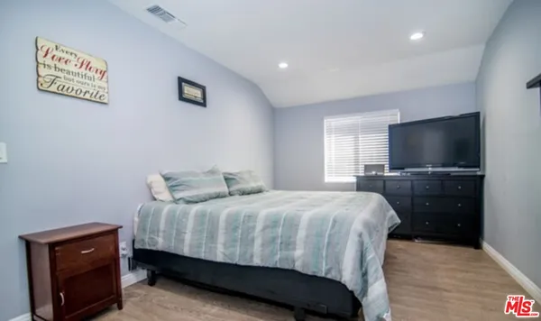a bedroom with a bed and a flat screen tv