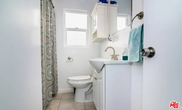 a bathroom with a sink toilet and window