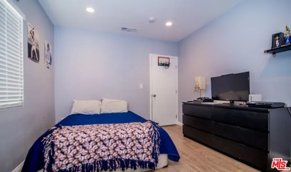 a bedroom with a bed and a flat screen tv