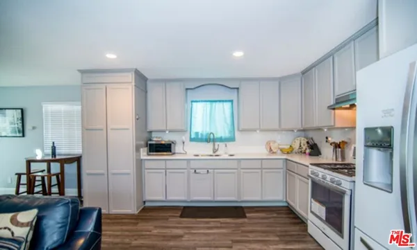 a kitchen with a sink a refrigerator and cabinets