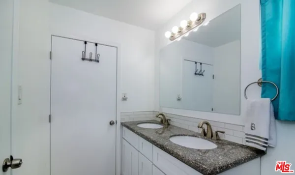 a bathroom with a granite countertop sink and a mirror