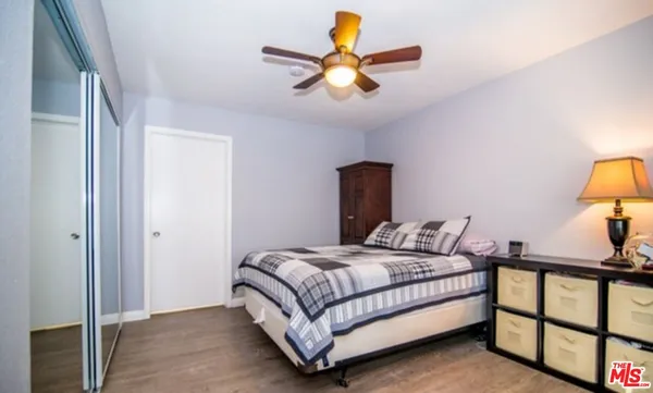 a bedroom with a bed and a painting on the wall