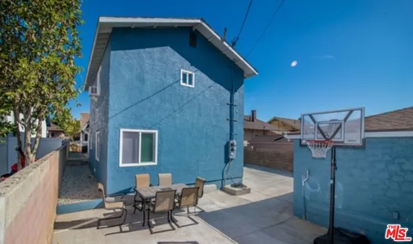 a backyard of a house with table and chairs