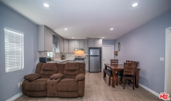 a living room with furniture a dining table and a window