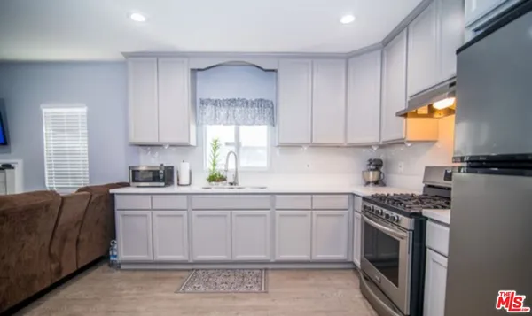 a kitchen with stainless steel appliances granite countertop a stove a sink and a microwave